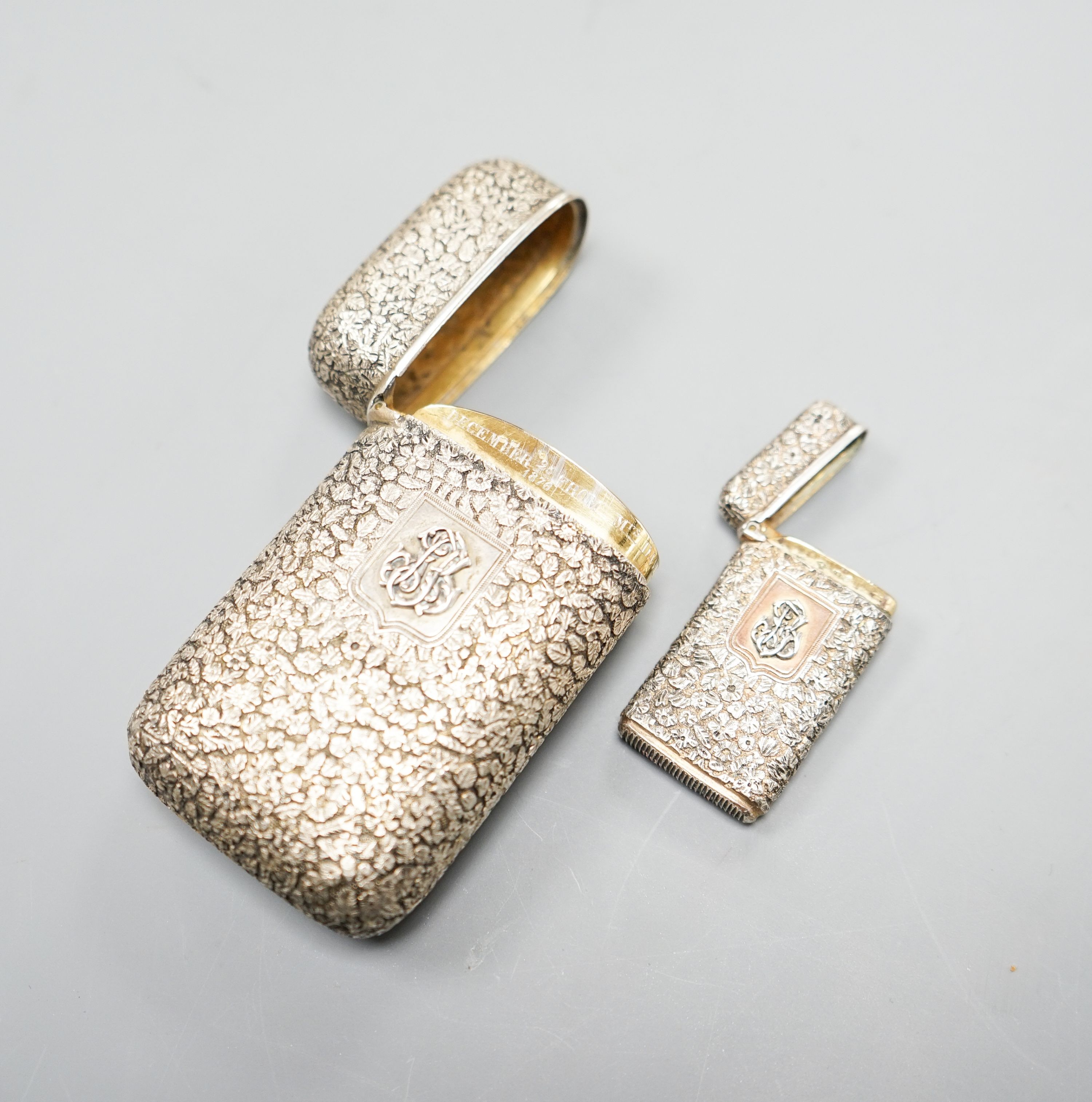 A late 19th century French embossed white metal cigarette case, 76mm, with monogram applique and a similar vesta case.